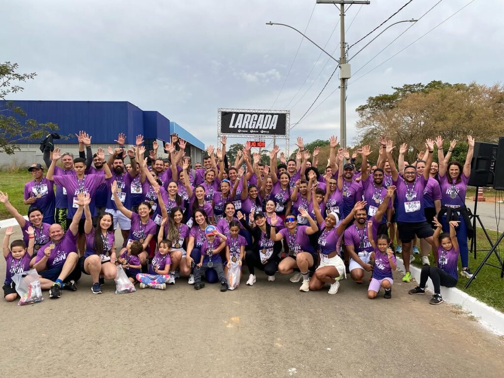 Colaboradores e familiares reunidos com medalhas na largada da 8ª edição da corrida DCCO Run.